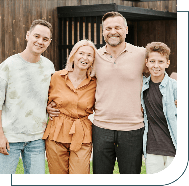 A family posing for the camera in front of a barn.